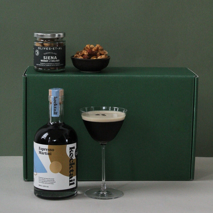 Glass of espresso martini against green gift box for him