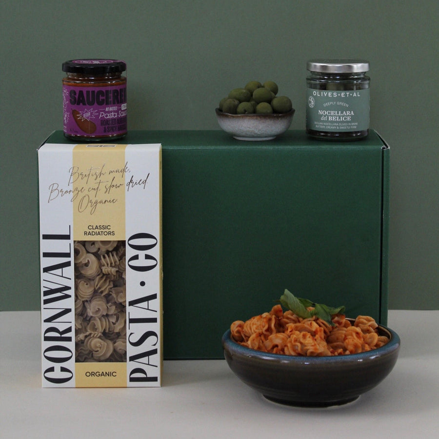 pasta gift box with sauce, pasta in a bowl against a green gift box