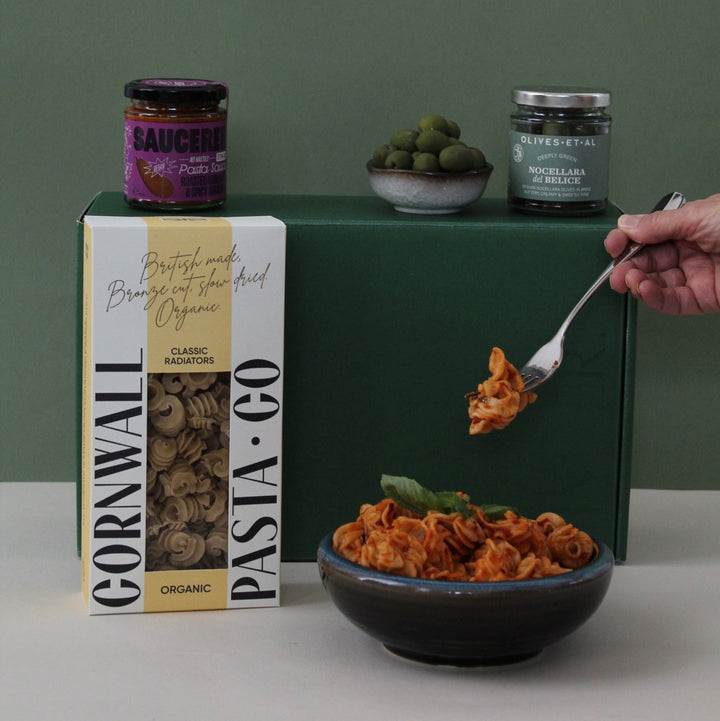 fork lifting pasta from a bowl, showing gift box contents