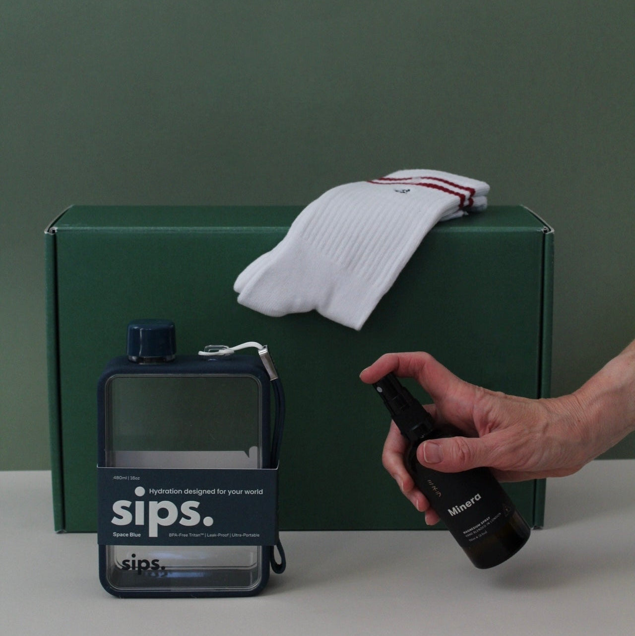green gift box with water bottle, magnesium spray and athlete socks